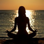 Woman in yoga lotus meditation at seaside